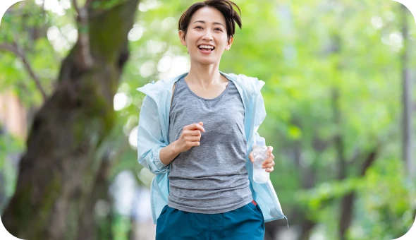 緑の中でランニングを楽しむ女性